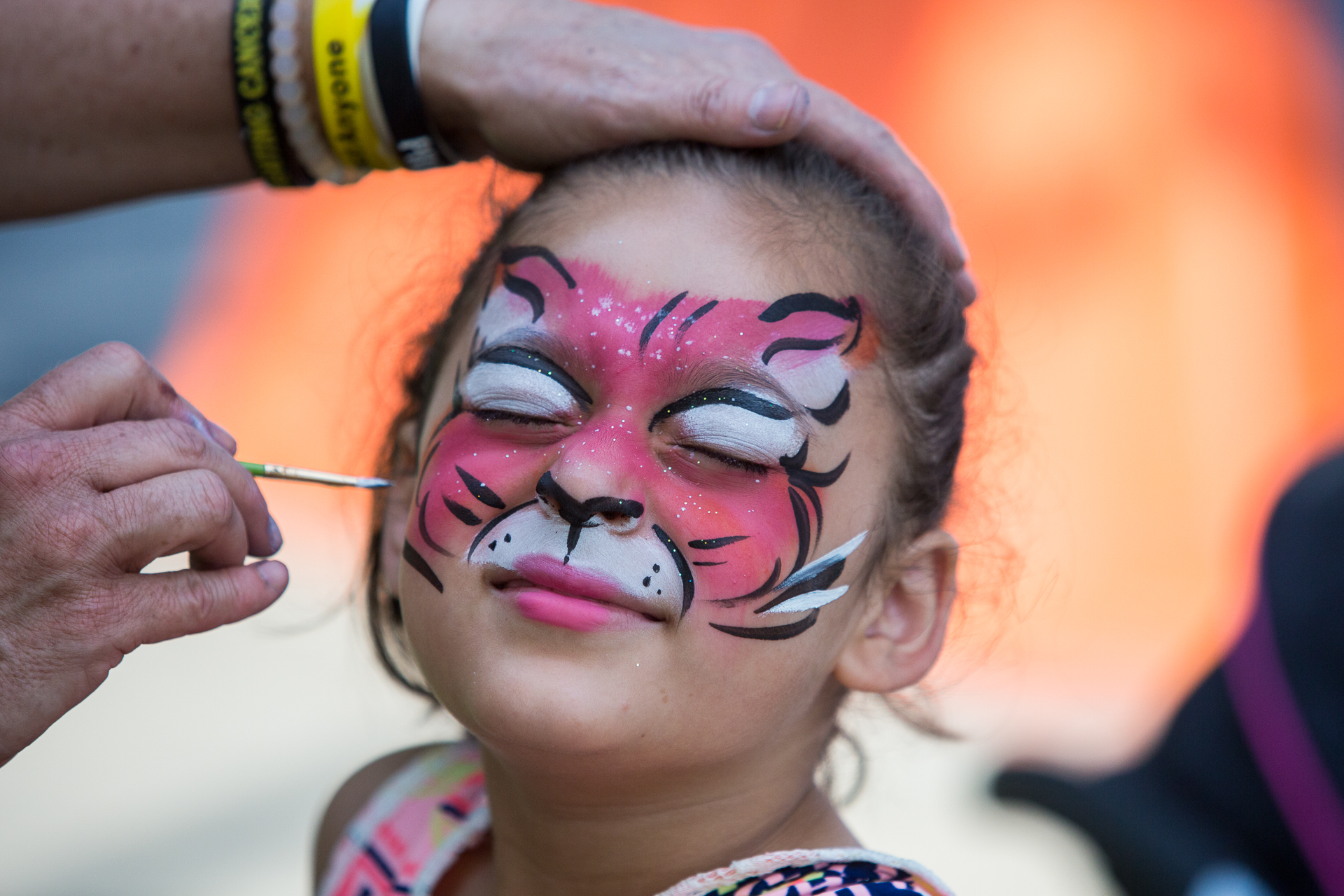 Stacy Pouerie, 7, of Greenbelt, Md., shuts her eyes while Michelle Johnson, “The Face Paint Lady,” paints her face at the Greenbelt Labor Day Festival, Sept. 5, 2016. The four-day festival featured rides, games, food and live entertainment. (© 2016 Eric Dietrich Photography)